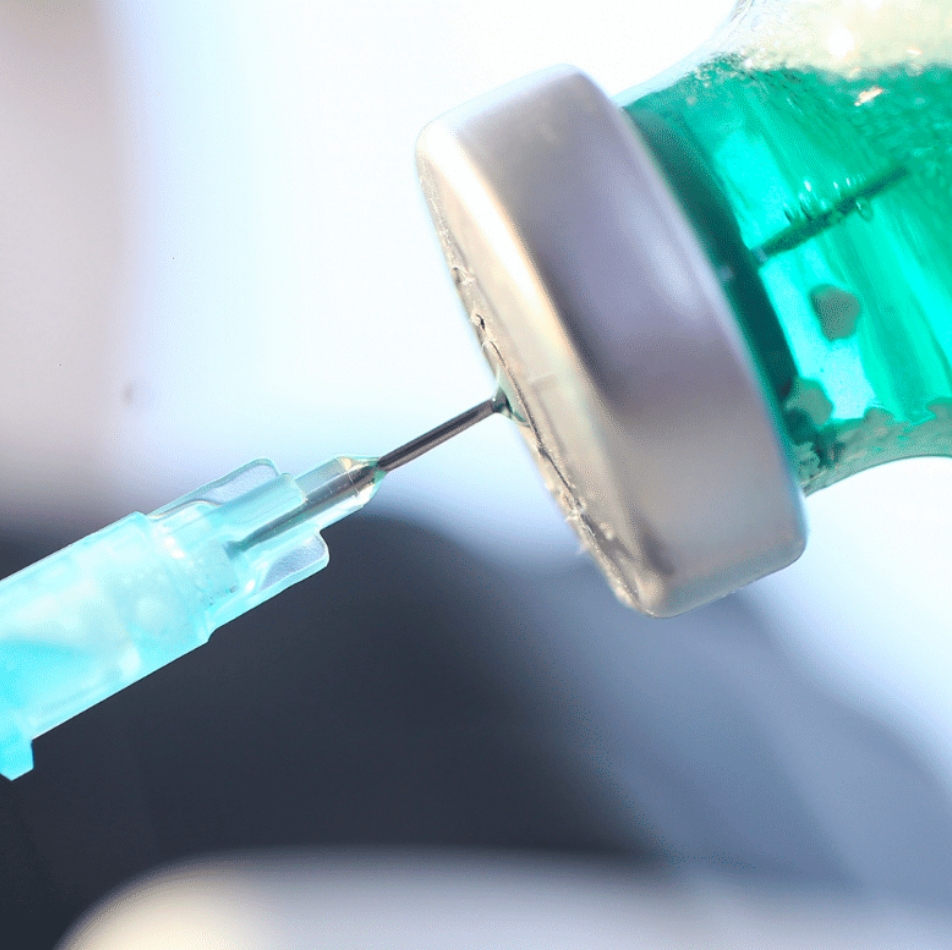 Syringe inserted into medicine bottle